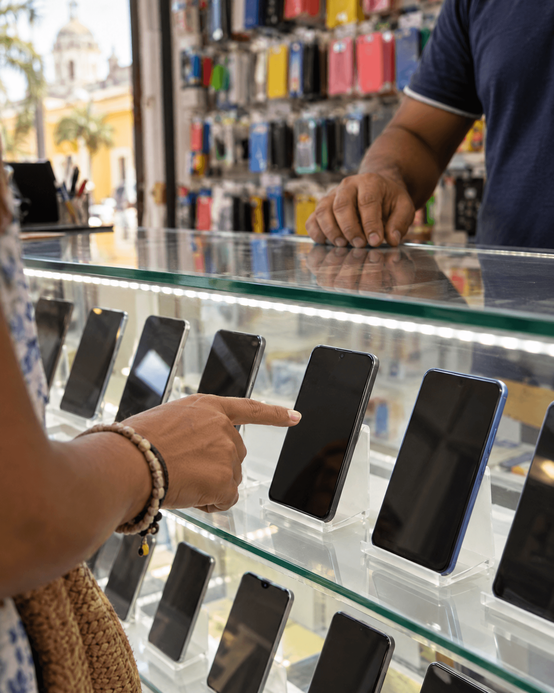 Una clienta elige su celular en la vitrina de una tienda afiliada.